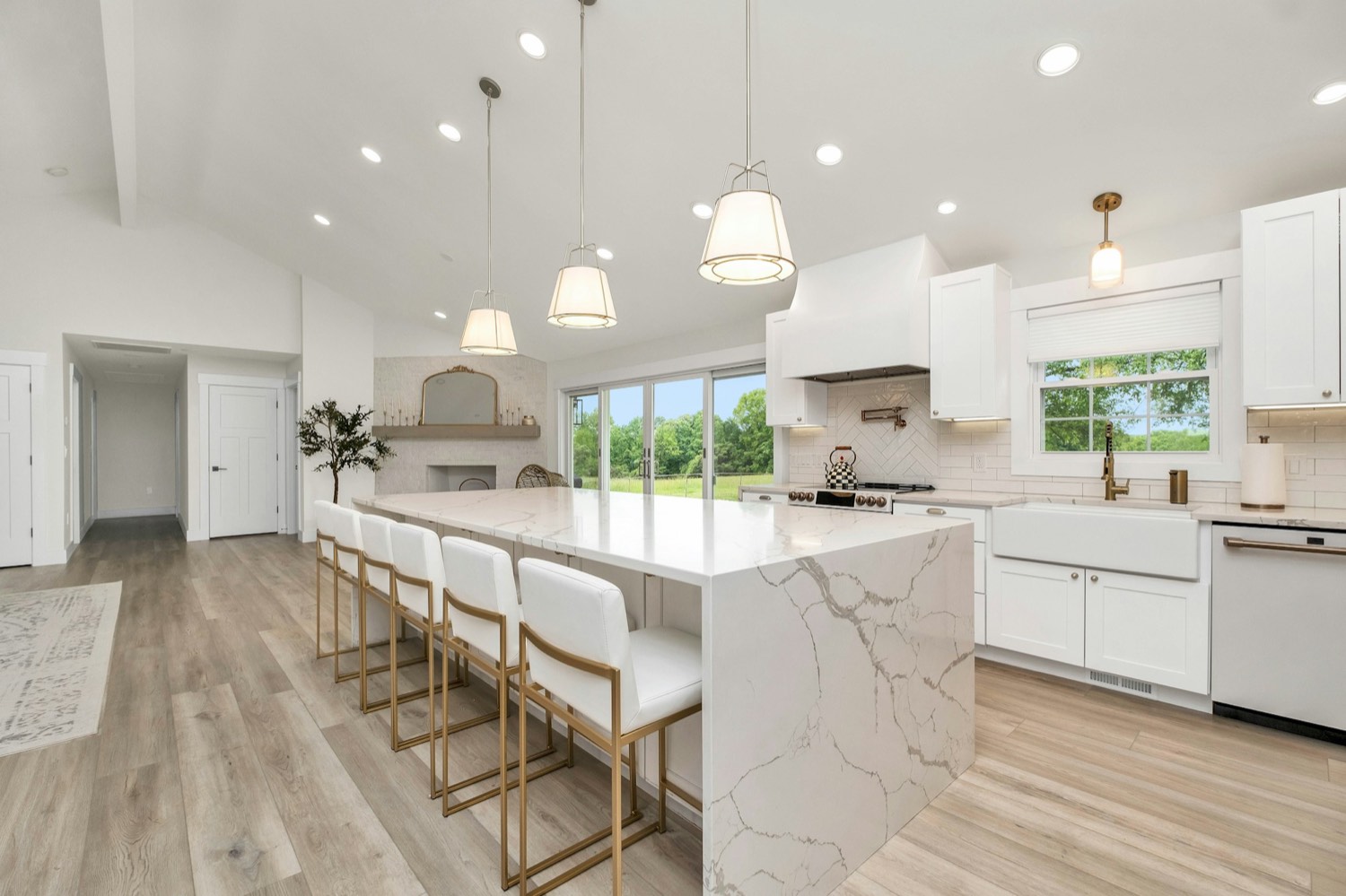 A white kitchen with a stone island bench